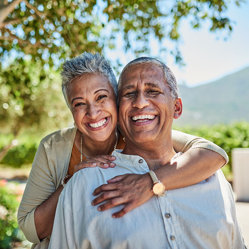 happy older black couple with gray hair embracing